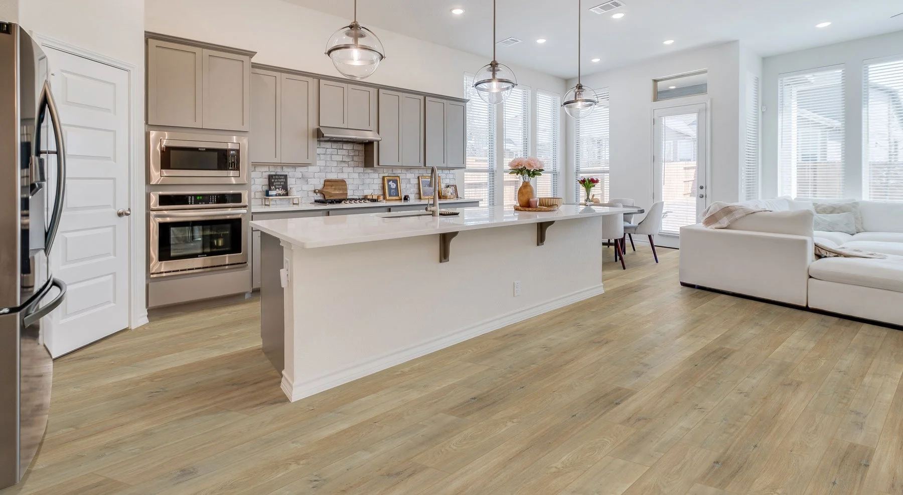 Bright open kitchen and living area with wide-plank flooring